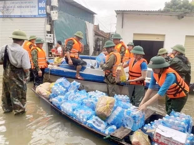Relief workers offer food and drinking water to flood victims in Nghe An. (Photo: VNA)