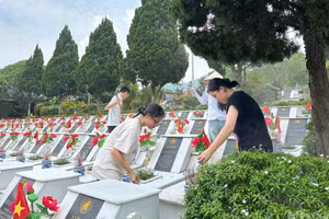 Students clean the grounds of the Vi Xuyen Martyrs’ Cemetery.