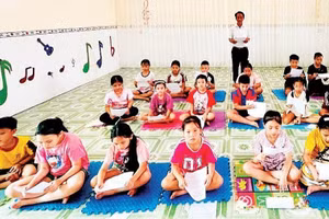 Meritorious Artisan Ngo Tri Minh teaches Vi and Giam folk songs to children.
