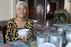 Artisan Dang Thi My Tram (Bau Truc Hamlet, Ninh Phuoc Commune, Khanh Hoa Province) alongside traditional handcrafted silver-engraved products of the Cham community. (Photo: NGUYEN TRUNG)
