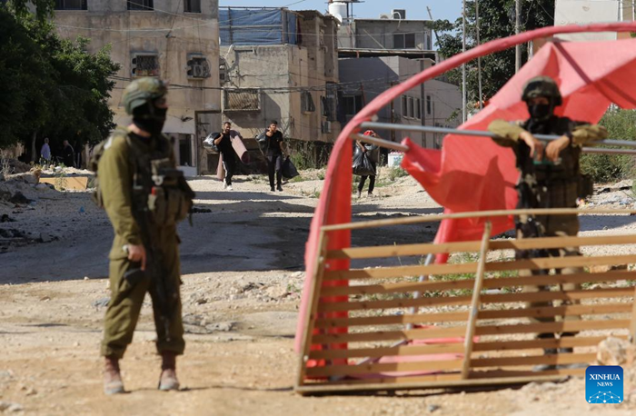Displaced Palestinians carrying their belongings are seen in Tulkarm refugee camp, northern West Bank, on July 6, 2025. Displaced Palestinians were allowed to return for belongings after the Israeli army announced the demolition of houses here. (Photo: Xinhua)