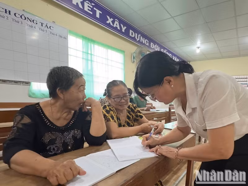 “Teacher” Dao Thi Thanh An guides Tran Thi Sen (in black shirt) and Nguyen Thi Huyen in writing.