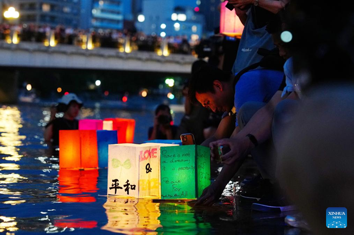 People place paper lanterns on a river at Hiroshima Peace Memorial Park in Hiroshima, Japan, on Aug. 6, 2025. The Japanese city of Hiroshima on Wednesday held a ceremony at the Peace Memorial Park to commemorate the 80th anniversary of the atomic bombing, while citizens gathered at the Hiroshima Atomic Bomb Dome to criticize the government's ongoing military buildup policies. (Photo: Xinhua)