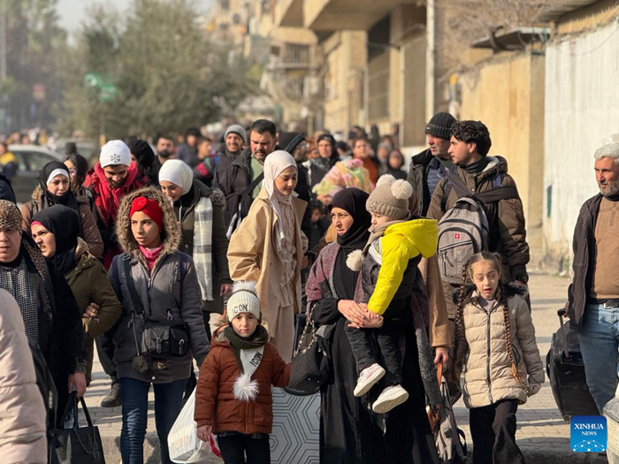 This photo taken with a mobile phone shows civilians leaving areas in the Sheikh Maqsoud and Ashrafieh neighborhoods in Aleppo city, northern Syria, on Jan. 7, 2026. Crowds of residents were forced to flee the predominantly Kurdish neighborhoods of Sheikh Maqsoud and Ashrafieh in the northern city of Aleppo on Wednesday, as clashes flared between the Syrian army and the Kurdish-led Syrian Democratic Forces (SDF). (Str/Xinhua)