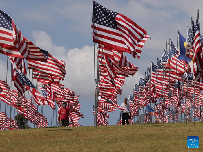 People walk among the Waves of Flags at Pepperdine University in Malibu, California, the United States, on Sept. 10, 2025. Each September, the university stages the Waves of Flags display to honor the victims of the 9/11 attacks. (Photo: Xinhua) 