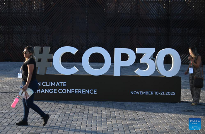 A woman walks past a logo of the upcoming 30th UN Climate Change Conference (COP30) in Belem, Brazil, Nov. 4, 2025. The COP30 will take place in the Amazon city of Belem from Nov. 10 to 21. (Photo: Xinhua).
