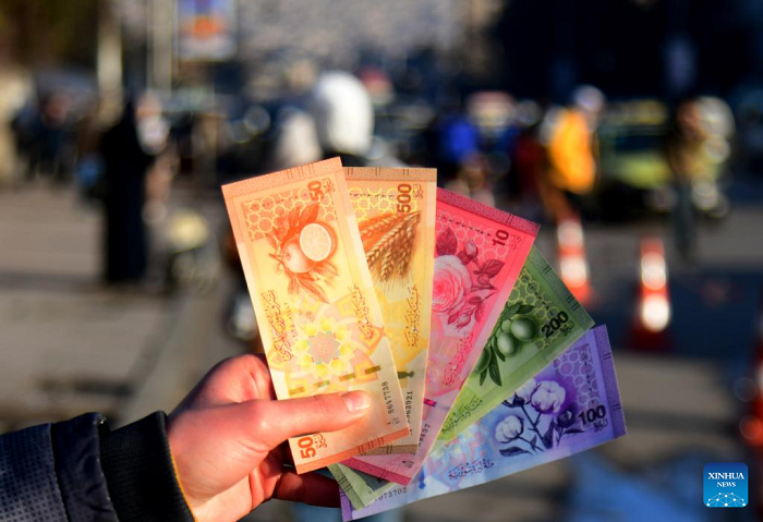 A Syrian citizen shows newly issued Syrian pound banknotes at a designated exchange point in Damascus, Syria, Jan. 4, 2026. Syria has begun circulating its new currency following a nationwide exchange process launched earlier this month. (Photo: Xinhua)
