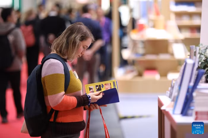 A woman visits the Frankfurt Book Fair in Frankfurt, Germany, Oct. 16, 2025. The world's largest book fair, the Frankfurt Book Fair, opened here on Tuesday with a focus on licensing and rights exchange. More than 4,000 publishers from over 90 countries and regions are present at the 77th book fair and more than 200,000 visitors are expected, said Juergen Boos, director of the Fair, at the opening ceremony. (Photo: Xinhua)