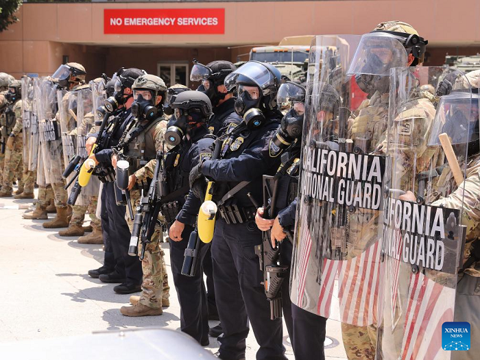 The California National Guard soldiers and police officers stand guard at the Los Angeles Federal Detention Center, in Los Angeles, California, the United States, June 8, 2025. More than 1,000 protesters clashed and faced off with National Guard troops in downtown Los Angeles on Sunday during the latest demonstrations against immigration raids that swept across California over the weekend. (Photo: Xinhua)