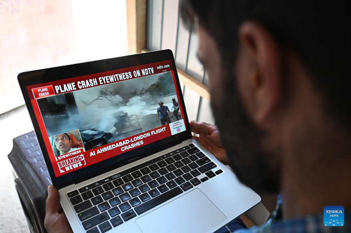 This photo taken in Srinagar, Indian-controlled Kashmir, shows a man watching the news of a plane crash in Ahmedabad of India's Gujarat state, June 12, 2025. An Air India flight to London crashed Thursday shortly after takeoff from an airport in the western Indian state of Gujarat, officials said. The flight with 242 people, including 230 passengers and 12 crew members, onboard took off from the Sardar Vallabhbhai Patel International Airport in Ahmedabad, about 17 km south of Gandhinagar, the capital city of Gujarat. (Photo: Xinhua)