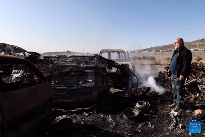 A Palestinian checks a vehicle scrapyard after Israeli settlers burned it in the town of Huwara, south of the West Bank city of Nablus, on Nov. 21, 2025. According to the official WAFA news agency, Israeli settlers set fire to a vehicle scrapyard here on Friday evening. (Photo: Xinhua)