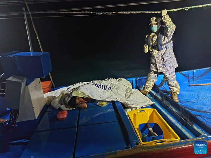 A survivor (L) rests aboard a boat on waters off Kedah, Malaysia, Nov. 9, 2025. At least one individual has been found dead and six have been rescued after a boat carrying nearly 100 undocumented migrants sank in waters near the Malaysia-Thailand maritime border, local police said on Sunday, according to Malaysia's national news agency Bernama. (Malaysian Maritime Enforcement Agency/Handout via Xinhua)