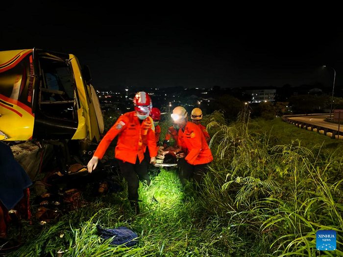 This photo provided by Indonesia's National Search And Rescue Agency (Basarnas) Semarang region shows rescuers transferring an injured passenger after a bus crash in Semarang, Central Java, Indonesia, Dec. 22, 2025. At least 15 people were killed and 19 others injured after a long-distance bus crashed at a toll road exit in Semarang, Central Java, Indonesia, early Monday, the local search and rescue authority said. (Basarnas Semarang/Handout via Xinhua)