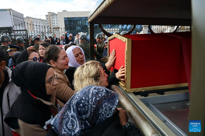 People mourn next to the coffins of soldiers killed in a Turkish military cargo plane crash, in Ankara, Türkiye, on Nov. 14, 2025. Türkiye on Friday held a funeral service for 20 soldiers who died in a military cargo plane crash. A solemn military ceremony was held at Ankara's Murted Air Base, attended by the soldiers' families, senior political figures, and top commanders of the Turkish Armed Forces. Following the ceremony, the bodies will be sent to their hometowns for burial. A Turkish Air Force C-130 cargo aircraft crashed in Georgia near the border with Azerbaijan on Tuesday, killing all 20 military personnel on board, including a 10-member maintenance team supporting F-16 fighter jets. (Mustafa Kaya/Handout via Xinhua)