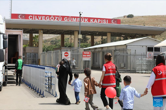 A Syrian family prepares to enter Syria from Türkiye under the escort of Turkish immigration workers at the Cilvegozu Border Gate in Reyhanli district of Hatay, Türkiye, Sept. 29, 2025. Turkish Interior Minister Ali Yerlikaya said on Monday that a total of 509,387 Syrians have returned to their country through the voluntary return process following the fall of former Syrian President Bashar al-Assad's regime in December 2024. (Mustafa Kaya/Handout via Xinhua)