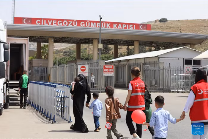 A Syrian family prepares to enter Syria from Türkiye under the escort of Turkish immigration workers at the Cilvegozu Border Gate in Reyhanli district of Hatay, Türkiye, Sept. 29, 2025. Turkish Interior Minister Ali Yerlikaya said on Monday that a total of 509,387 Syrians have returned to their country through the voluntary return process following the fall of former Syrian President Bashar al-Assad's regime in December 2024. (Mustafa Kaya/Handout via Xinhua)