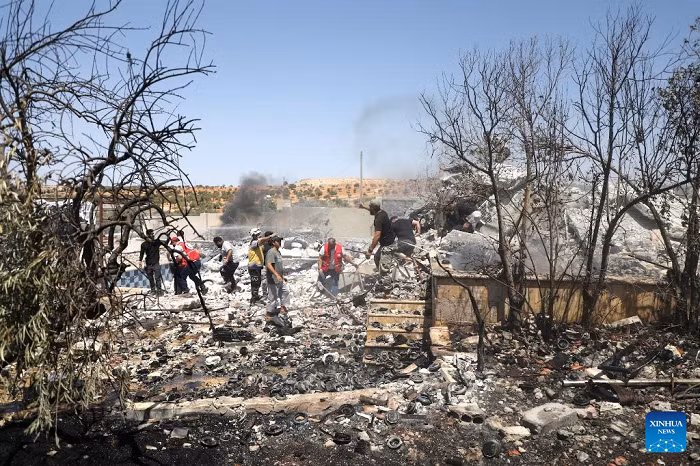 Rescue workers and residents search through the rubble following an explosion in Idlib, Syria, Aug. 14, 2025. A powerful explosion shook the countryside of Syria's Idlib province on Thursday, killing at least four people and injuring five others, according to Syrian state media and a war monitoring group. (Str/Xinhua)