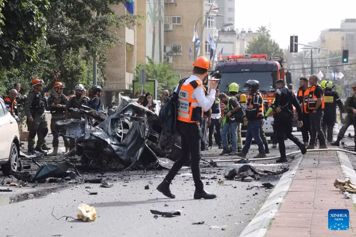 Israeli security forces and emergency responders are seen at the site of a missile attack in Ramat Gan, central Israel, April 4, 2026. (JINI via Xinhua)