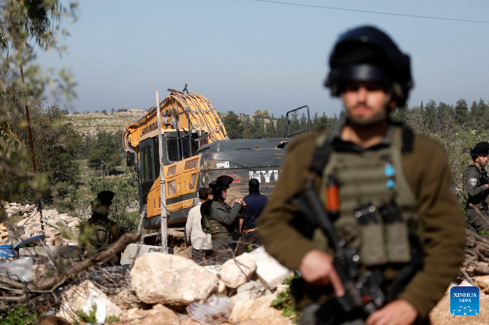 Israeli soldiers are seen as an Israeli military excavator demolishes a Palestinian home in the town of Beit Awa, west of Hebron in the West Bank, on Feb. 5, 2026. (Photo: Xinhua)