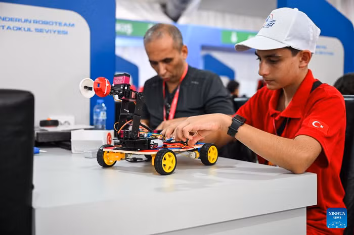 A participant adjusts a robot at the technology event TEKNOFEST in Istanbul, Türkiye, Sept. 17, 2025. The five-day event kicked off here on Wednesday, showcasing sci-tech advancements in fields such as aerospace, education and healthcare. (Photo: Xinhua)