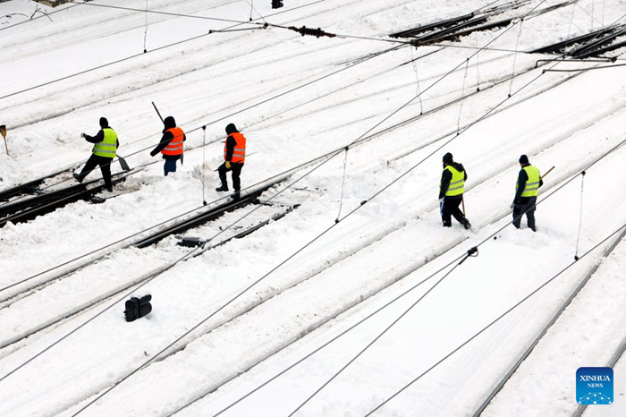 Workers clean snow at North Railway station in Bucharest, Romania, on Feb. 18, 2026. A heavy snowstorm hit southern and southeastern Romania overnight, prompting a red alert in Bucharest and disrupting road, air and maritime traffic, authorities said on Wednesday. (Photo: Xinhua)