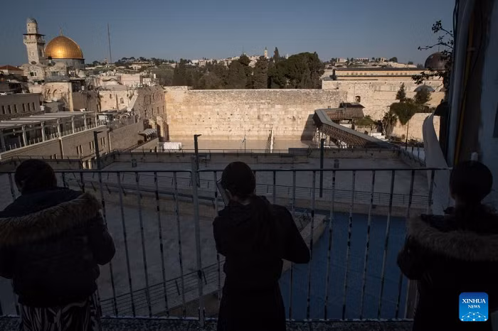 People pray facing the Western Wall from an elevated platform, in Jerusalem's Old City, March 5, 2026. Israeli police tighten security across Jerusalem's Old City, closing the Western Wall and its plaza amid persisting regional tensions. (Photo: Xinhua)