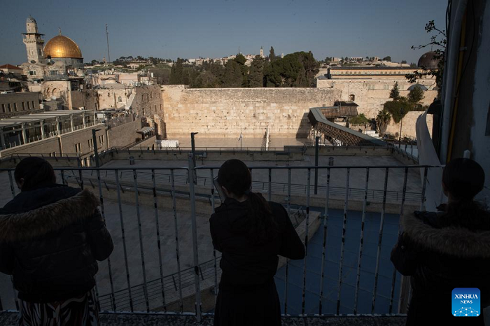 People pray facing the Western Wall from an elevated platform, in Jerusalem's Old City, March 5, 2026. Israeli police tighten security across Jerusalem's Old City, closing the Western Wall and its plaza amid persisting regional tensions. (Photo: Xinhua)
