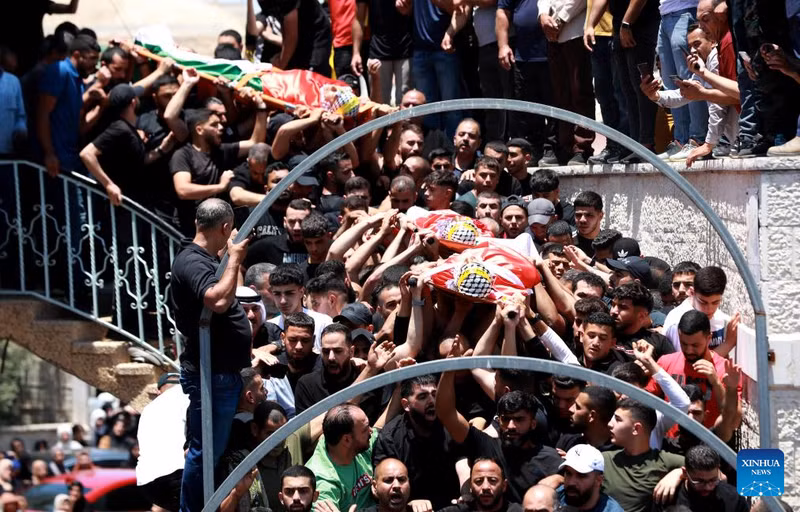 People carry the bodies of three Palestinians killed in an Israeli settler attack in the town of Kafr Malik east of Ramallah, central West Bank, on June 26, 2025. Three Palestinians were killed and seven others injured on Wednesday by live bullets during an Israeli settler attack on the town of Kafr Malik east of Ramallah, central West Bank, the Palestinian official news agency WAFA reported. (Photo: Xinhua)