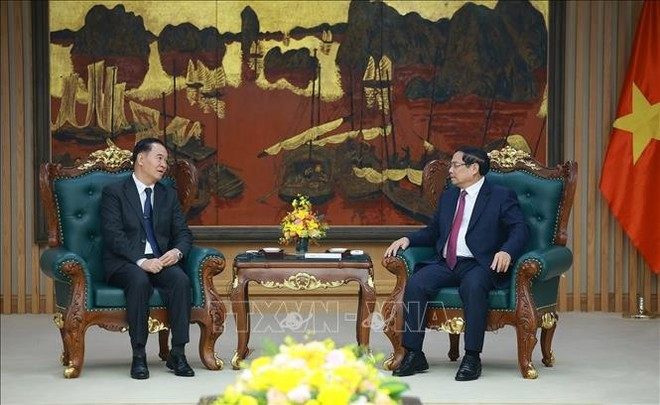 Prime Minister Pham Minh Chinh (R) receives Lao Minister of Education and Sports Thongsalith Mangnormek in Ha Noi on December 16 (Photo: VNA)