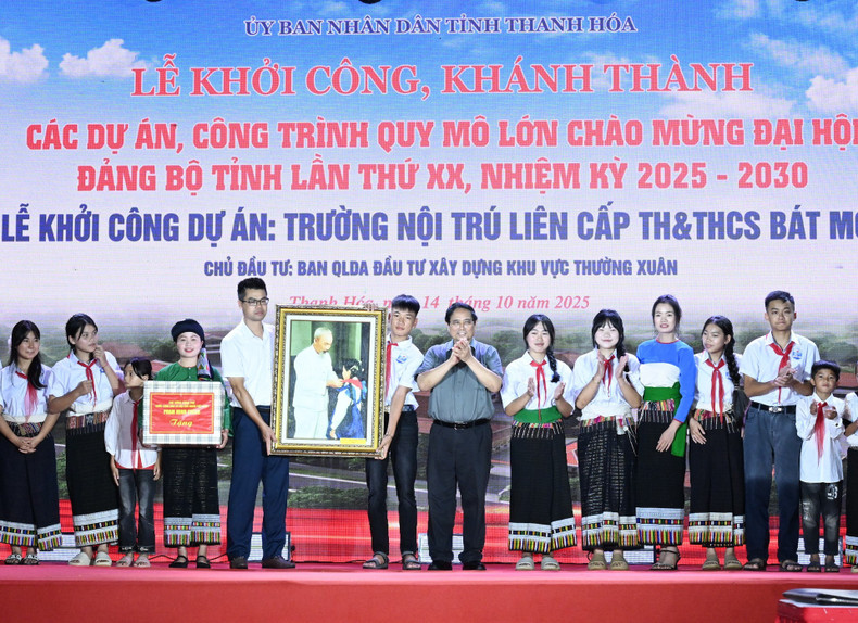 The prime minister presents a painting entitled “President Ho Chi Minh tying red scarves for pupils” to the teachers and students of Bat Mot Boarding School for Primary and Lower Secondary Students. image-7.jpg
