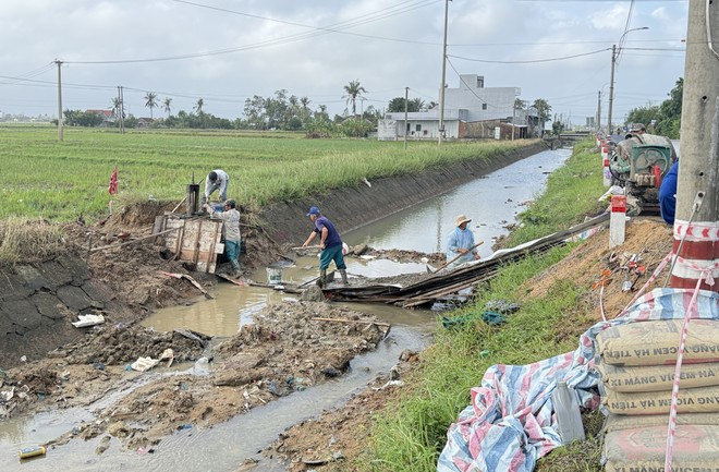Workers urgently repair sections of Chinh Nam canal damaged by flooding. (Photo: VNA)