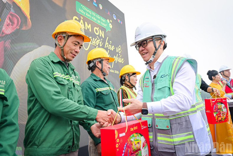 Le Quoc Minh, Editor-in-Chief of Nhan Dan Newspaper, presents gifts to workers at the programme.