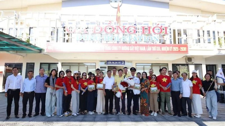 A representative of the Quang Tri Department of Culture, Sports and Tourism presents flowers and poses for souvenir photos with the train staff and tourists. image-3.jpg