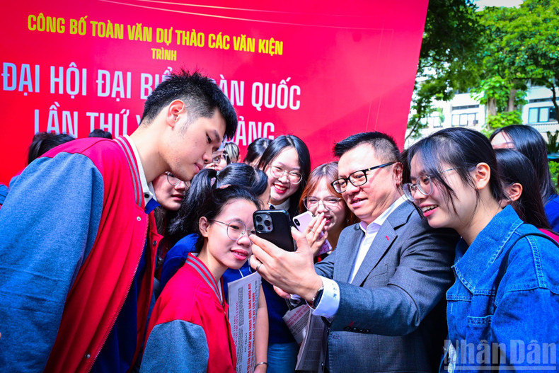 Le Quoc Minh, Editor-in-Chief of Nhan Dan Newspaper, guides young readers on how to access the official website of the 14th National Party Congress to submit their feedback on the draft documents.