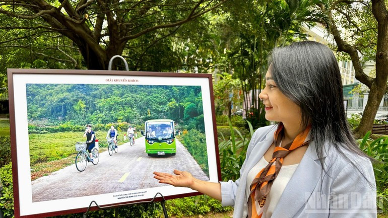 Photographer Nguyen Thi Hung from Hai Phong happily poses with her work at the exhibition. image-7.jpg