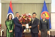 Ambassador Pham Thanh Binh presents flowers to congratulate the Lao Embassy. (Photo: Vietnamese Embassy in China)