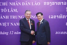 General Secretary and President of Laos Thongloun Sisoulith congratulates General Secretary To Lam on receiving the National Gold Order — the highest honour of the Lao state. (Photo: VNA)