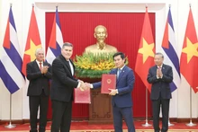 General Secretary of the Communist Party of Viet Nam Central Committee To Lam (R, second row) and First Secretary of the Communist Party of Cuba Central Committee and President of Cuba Miguel Díaz-Canel Bermúdez witness exchange of the minutes of the 42nd session of the Viet Nam–Cuba Intergovernmental Committee on economic and scientific–technical cooperation. (Photo: VNA)
