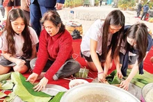 Students experience wrapping banh chung with members of the Intergenerational Self-Help Club in Khuong Dinh Ward (Ha Noi City).