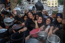 Palestinians await free food distribution at a centre in Gaza City on July 14, 2025. (Photo: Xinhua)