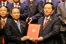 Chairman of the Party Central Committee's Commission for Information, Education, and Mass Mobilisation Nguyen Trong Nghia (R) presents the Politburo's decision to Thai Dai Ngoc, who now serves as Secretary of the Gia Lai provincial Party Committee. (Photo: VNA)