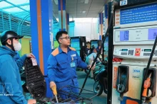 Customers buy and sell fuel at a Petrolimex petrol station. (Photo: VNA)