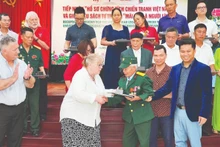 Representatives of Texas Tech University hand over documents to war veteran and wounded soldier Do Xuan Thuyen.