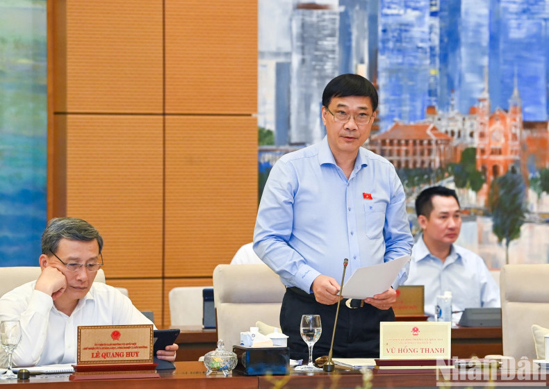 Chairman of the NA's Economic Committee Vu Hong Thanh presents a verification report on the socio-economic report.