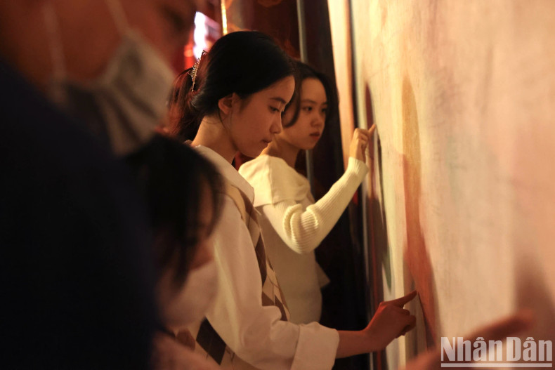 Young people are excitedly writing their wishes for a new successful year on the wall by hand. Young people are excitedly writing their wishes for a new successful year on the wall by hand.