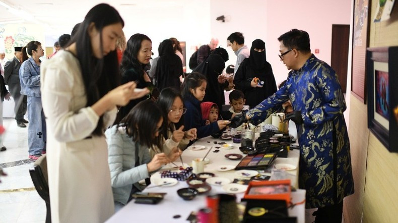 Visitors experience crafting handmade items such as necklaces, bracelets, plates, and cups using traditional Vietnamese lacquer art.