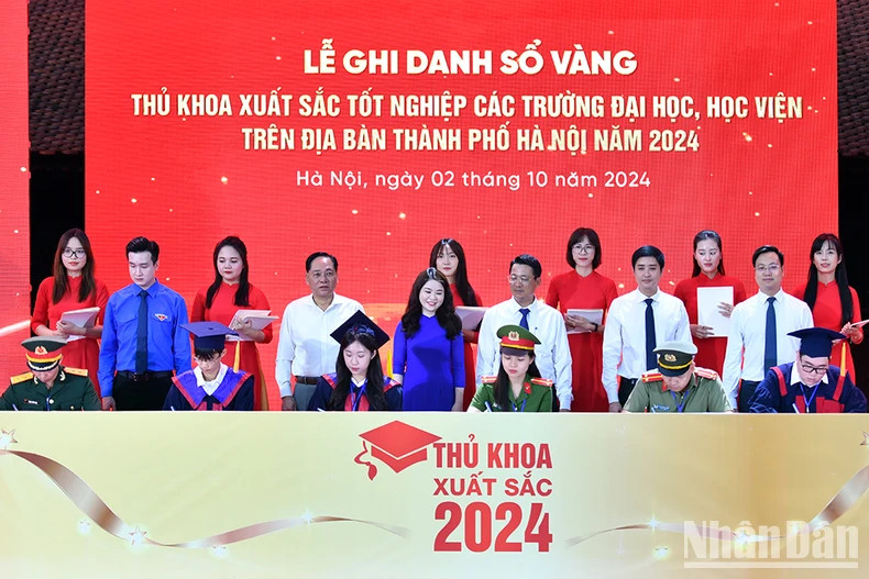 The valedictorians sign their names in the Golden Book under the presence of representatives from the leadership of Hanoi and relevant departments, agencies, and organisations.