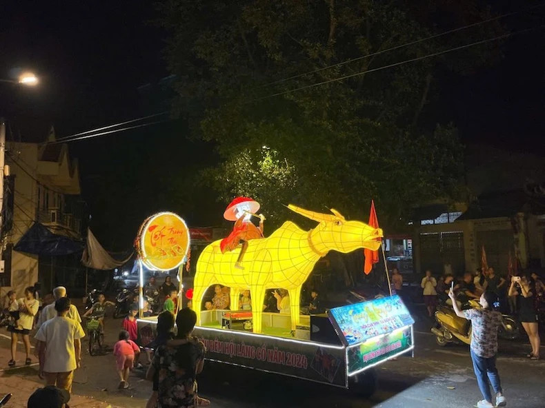 A lantern model featuring a golden buffalo and a young shepherd from the Cam Thinh village team.