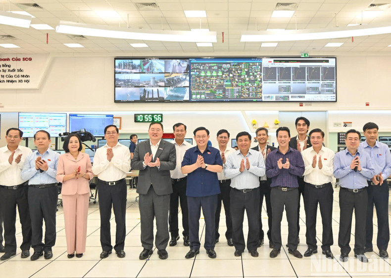 NA leader Vuong Dinh Hue poses for a photo with leaders, officers, engineers and workers of the Long Son Petrochemical Complex Project.