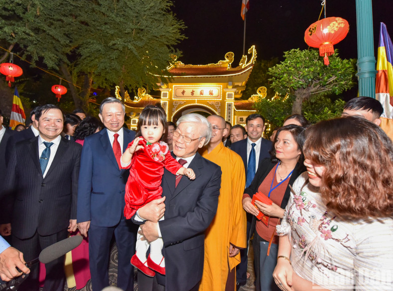 Party General Secretary and President Nguyen Phu Trong talks with Hanoi citizens on New Year's Eve at Tran Quoc Pagoda.
